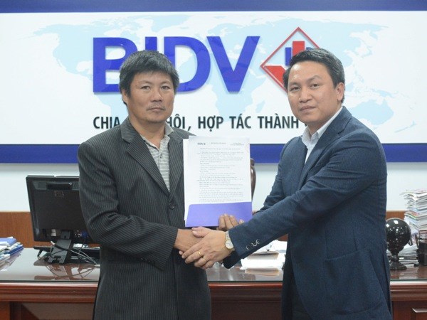 Lãnh đạo BIDV trao hợp đồng cho ông Trần Huấn. (Nguồn: BIDV)
